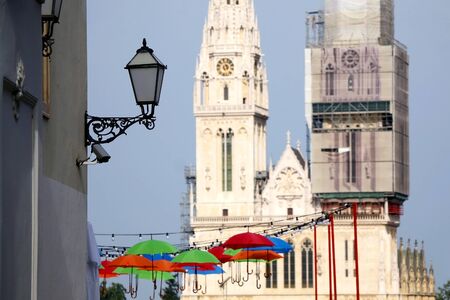 Colorful umbrellas and street light in Zagreb, Croatia. Cathedral of the Assumption of the Blessed Virgin Mary in the background. Selective focus.の写真素材