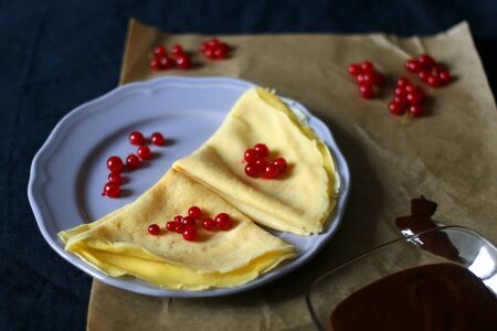 Homemade crepes with chocolate spread and red currants. Selective focus.の写真素材