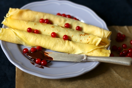 Homemade rolled crepes with chocolate spread and red currants. Selective focus.の写真素材