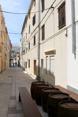 Traditional barrels set as tables on the narrow street of town Pag, island Pag, Croatia.の写真素材