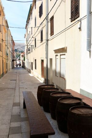 Traditional barrels set as tables on the narrow street of town Pag, island Pag, Croatia.の写真素材