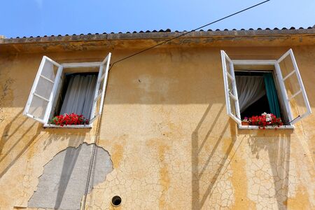 Old house with flowers in the windows in town Pag, island Pag, Croatia.の写真素材