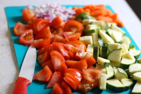 Chopped vegetables on a cutting board: tomato, zucchini, carrot and onion. Selective focus.の写真素材