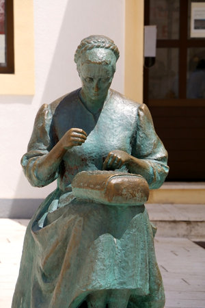 Pag, Croatia - July 7, 2019: Monument dedicated to female embroiderer in town Pag, on island Pag, Croatia. Embroidery and lace work is traditional symbol of Pag.のeditorial素材