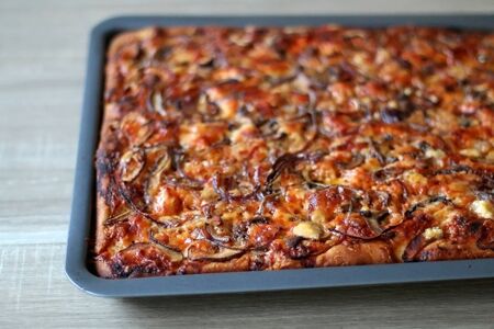 Close-up view of baked homemade vegetarian pizza with tomato sauce, cheese, mushrooms and onion. Selective focus.の写真素材