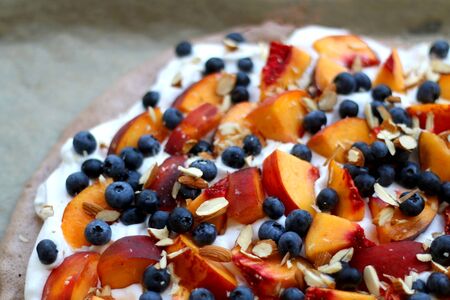 Chocolate Pavlova cake with whipped cream, peaches, blueberries and almonds. Selective focus.の写真素材