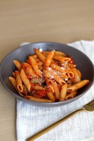 Plate of pasta with tomato sauce and eggplant, sprinkled with grated parmesan. Selective focus.の写真素材