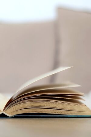 Open book on a living room table. Selective focus.の写真素材