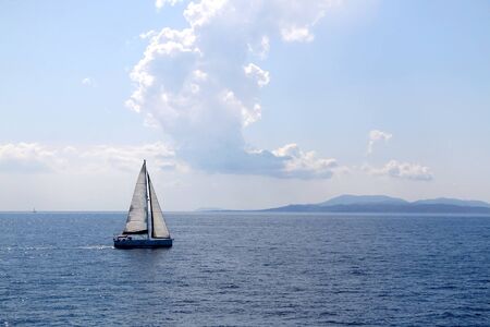 Landscape in Dalmatia, Croatia with sailing boat, sea, island and unusual clouds.