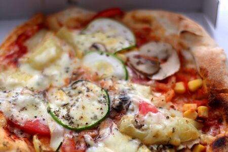 Small vegetarian pizza in a box. Take away food. Selective focus.の写真素材
