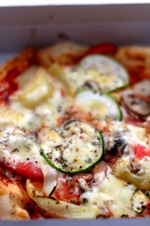 Small vegetarian pizza in a box. Take away food. Selective focus.の写真素材