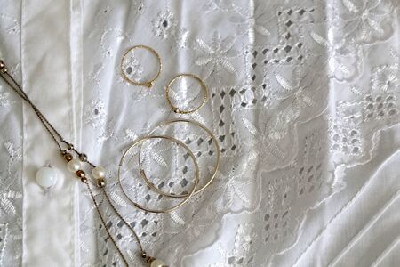 Vintage white lace blouse with silver and gold jewelry. Top view.の写真素材
