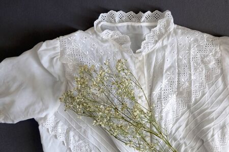 Vintage white lace blouse and gypsophila flowers. Top view.の写真素材