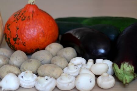 Pile of seasonal vegetables on wooden table: pumpkin, squash, zucchini, potato eggplant, pepper, carrot and mushroom. Selective focus.の写真素材
