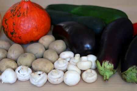 Pile of seasonal vegetables on wooden table: pumpkin, squash, zucchini, potato eggplant, pepper, carrot and mushroom. Selective focus.の写真素材