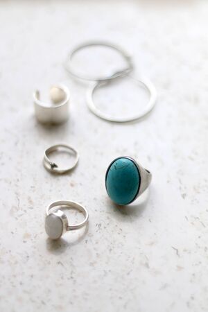 Â¸Silver rings and earrings on marble background. Selective focus.の写真素材