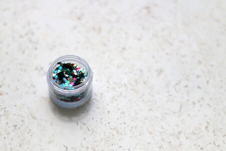 Colorful glitter stars, make-up for face and body, on marble background. Selective focus.の写真素材