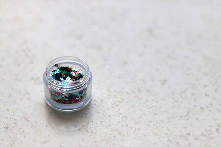 Colorful glitter stars, make-up for face and body, on marble background. Selective focus.の写真素材