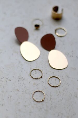 Gold rings and earrings on marble background. Selective focus.の写真素材