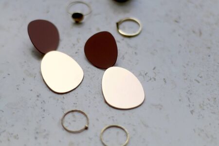 Gold rings and earrings on marble background. Selective focus.の写真素材