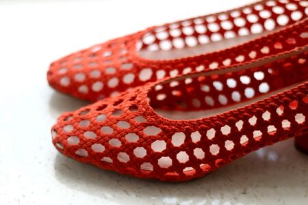 Trendy red mesh shoes, on marble background. Selective focus.の写真素材