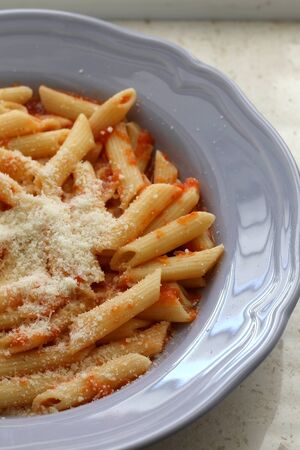 Plate of pasta with homemade tomato sauce. and grated parmesan cheese on top. Selective focus.の写真素材