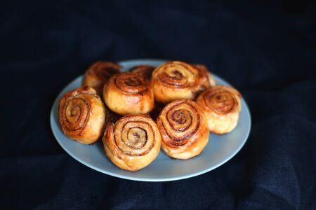 Homemade cinnamon rolls on a plate. Selective focus, dark background.の写真素材
