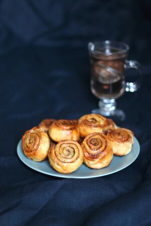 Homemade cinnamon rolls on a plate. Selective focus, dark background.の写真素材