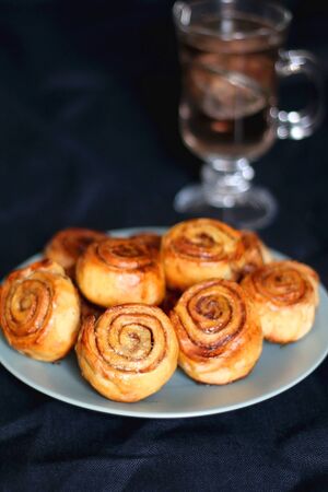Homemade cinnamon rolls on a plate. Selective focus, dark background.の写真素材