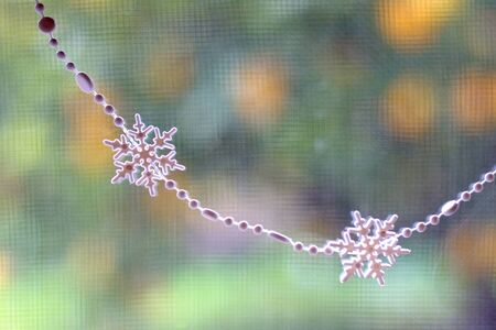 Christmas garland with snowflakes hanged on a window. Selective focus.の写真素材