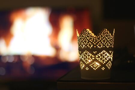 Candle holder in front of a fireplace at night. Selective focus.の写真素材