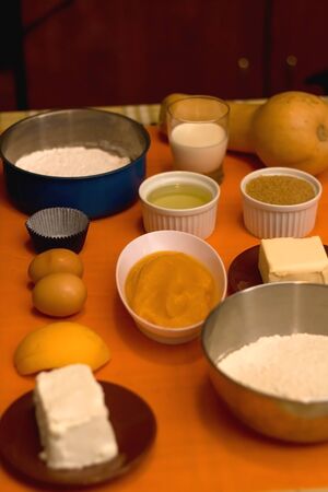 Cupcake ingredients on a table: pumpkin puree, flour, eggs, butter, sugar and nuts. Selective focus.の写真素材