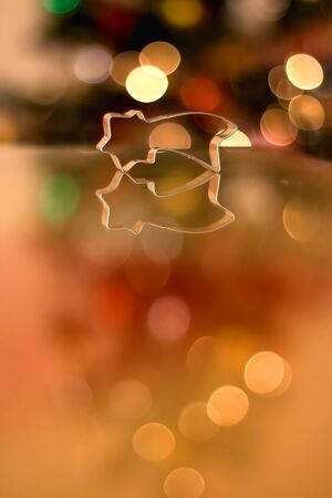Cookie cutter shaped like star. Christmas tree in the background. Selective focus.の写真素材