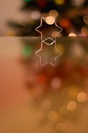 Cookie cutter shaped like star. Christmas tree in the background. Selective focus.の写真素材