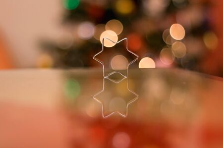 Cookie cutter shaped like star. Christmas tree in the background. Selective focus.の写真素材