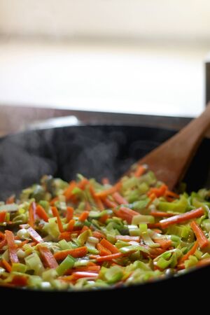 Carrot, leek and pumpkin, stir frying in a wok. Selective focus.の写真素材