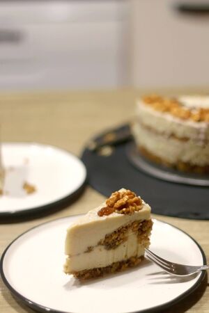 Slice of vegan cake with walnuts, cashew nuts and raisins. Selective focus.の写真素材