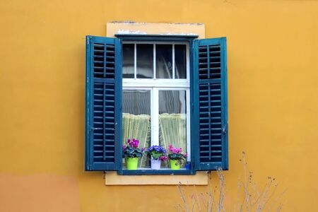 Traditional Mediterranean window with wooden shutters in Split, Croatia. Traditional colorful architectural detail, decorated with plants and flowers.の写真素材