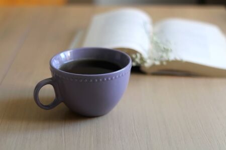 Cup of tea, book and gypsophila flowers on wooden table. Selective focus.の写真素材