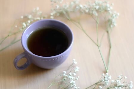Cup of tea and gypsophila flowers on wooden table. Selective focus.の写真素材