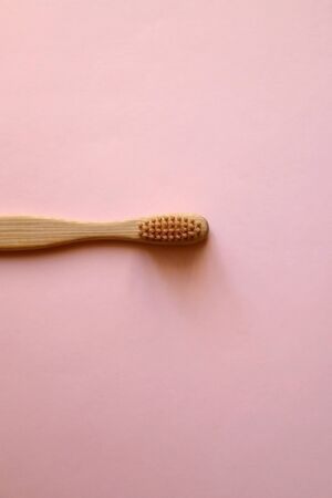 Bamboo toothbrush on pale pink background. Zero waste lifestyle concept. Flat lay.の写真素材