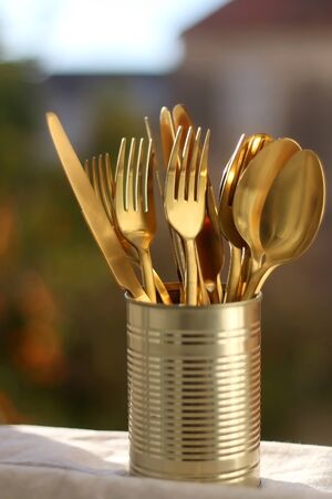 Gold colored cutlery in a can. Selective focus.の写真素材