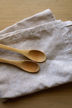 Linen dish cloth and wooden spoons. Top view.の写真素材