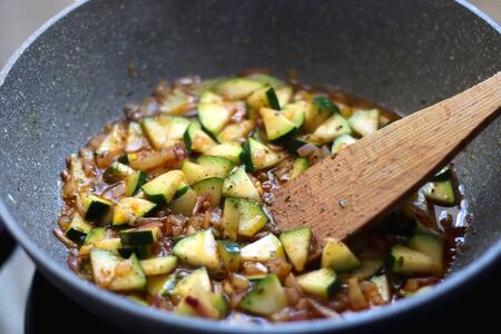 Chopped zucchini, onions and olive oil in a frying pan. Selective focus.の写真素材