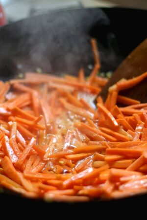 Stir fry carrot in a wok. Selective focus.の写真素材