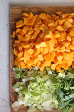 Chopped leek and carrots on a wooden cutting board. Top view.の写真素材
