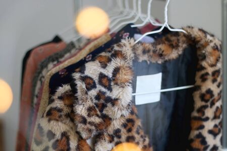 Colorful eccentric wardrobe on a clothing rack. Selective focus, bokeh lights in the foreground.