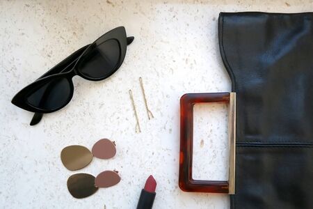 Fashionable accessories and jewelry on a marble background. Top view.