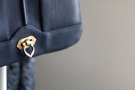 Black classis vintage bag on a clothing rack. Selective focus, close-up.