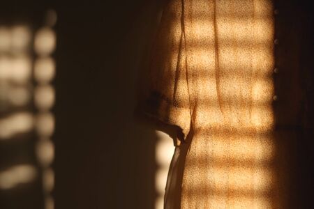Vintage yellow floral dress, illuminated by sunlight. Selective focus.